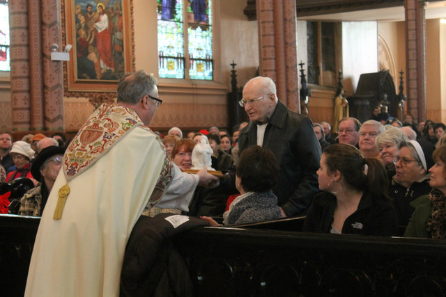 <p>Rev. Jeremiah Boland presents John Latham, 93, who was an alter boy of the Holy Family Church in the 1930s, with a plaque of the Holy Family.</p>
