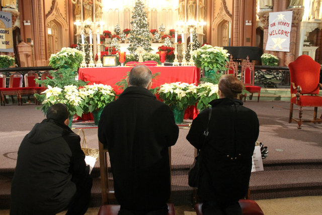 <p>Ben Cardenas Jr, 32, and his parents, Ben Cardenas Sr and Angelina Cardenas, pray near the holy relics</p>
