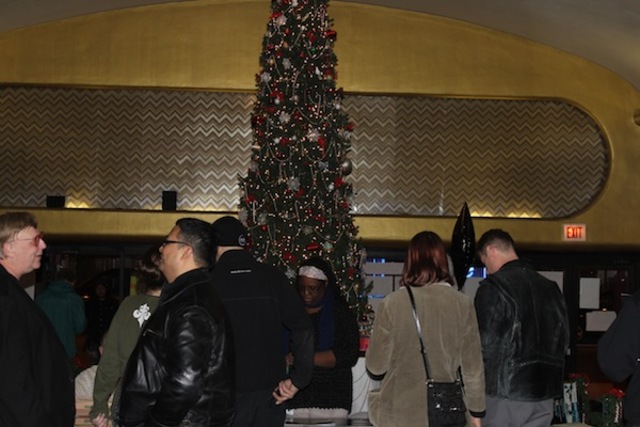<p>People gather in the lobby of the Portage Theater to examine items donated by local businesses for a raffle to raise money to pay the theater operators' legal bills.</p>
