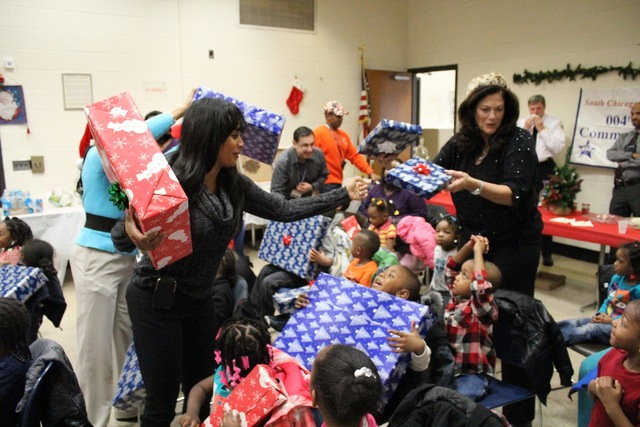 <p>Ald. Sandi Jackson (7th) helps hand out presents to preschoolers visiting Santa at the South Chicago District police station.</p>
