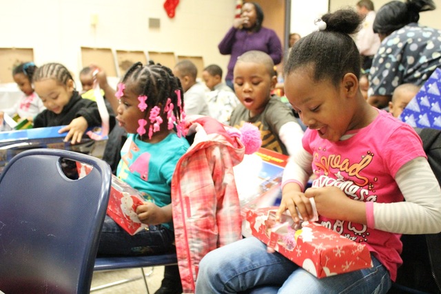 <p>Preschoolers from the Ada S. McKinley Trumbull Park Head Start program open presents from their local police district.</p>
