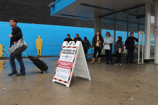 <p>Riders leaving the Logan Square Blue Line station watch the shoot.</p>
