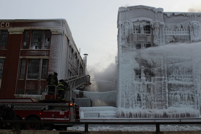 <p>Firefighters blast water on the warehouse on South Ashland Avenue on Thursday after the fire rekindled about two and a half days later.</p>
