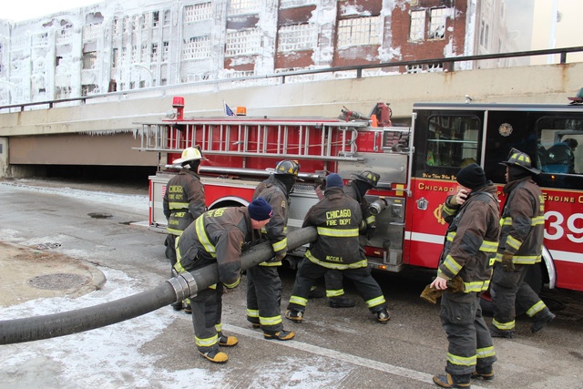 <p>Firefighters get ready to blast the South Ashland Avenue warehouse on Thursday, when the fire department said a fire rekindled in the building.</p>

