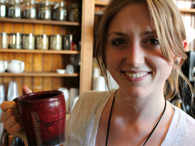 <p>Cassandra Andrewson, 21, a barista at Bridgeport Coffee Company, holds one of Jay Strommen's handcrafted mugs.</p>
