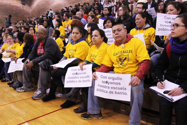 <p>A parent from Gale Elementary holds a sign in support of his school.</p>
