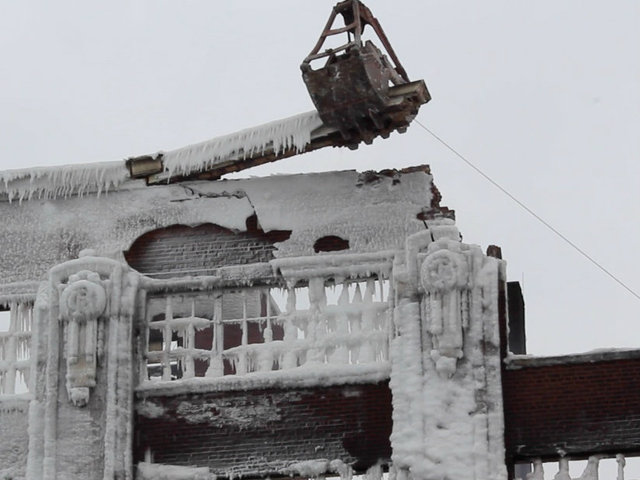 <p>Construction crews began their teardown of a still-burning Bridgeport warehouse on Friday</p>
