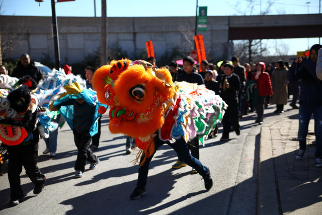 <p>Parade participants dance with a colorful orange dragon at the 2013 Chinese New Year Parade in Chicago's Chinatown.</p>
