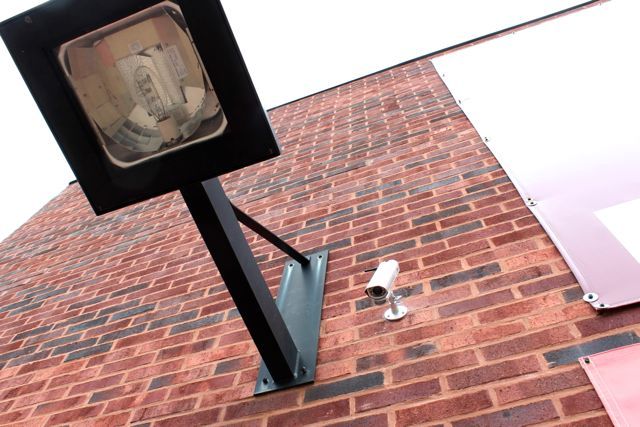 <p>A 24-Hour ATM was installed at 1704 N. Milwaukee Ave. on the southern end of a strip mall, in front of a handicap parking space, obscured by a garbage bin and next to a wall and bush. A security camera is positioned above the machine along with bright lights.</p>
