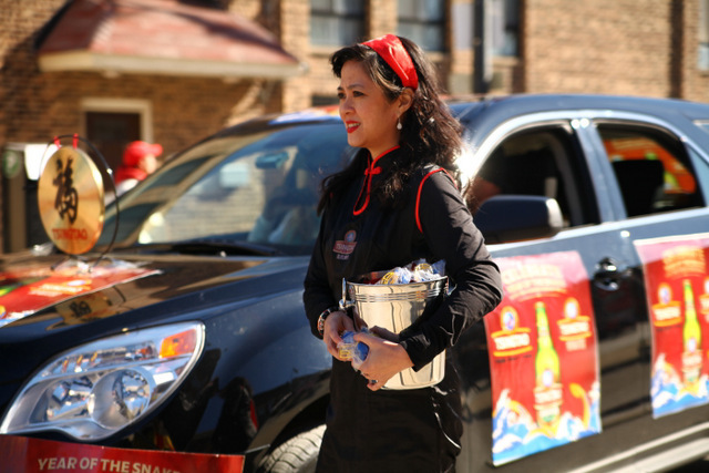 <p>A girl passes out favors at the Chinese New Year parade 2013.</p>
