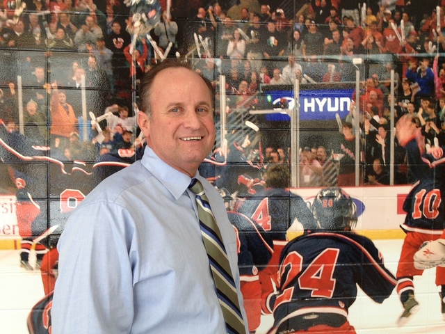 <p>St. Rita hockey coach Craig Ferguson poses in front of a mural honoring the team's 2012 state championship. St. Rita also won a state title in 2010.</p>
