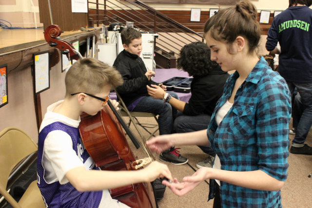 <p>Emina Sisic (r), a sophomore at Amundsen High School, provides cello lessons to students at McPherson Elementary.</p>
