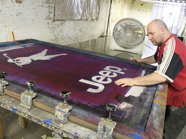 <p>Screen printer John Svihula works on a sign for a corporate client at Advertising Flag Co. in McKinley Park.</p>
