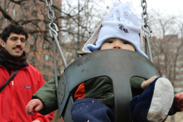 <p>Sieji Ginsburg, nearly a year old, is pushed on a swing in Telscer Park by his father, Jonas Ginsburg.</p>
