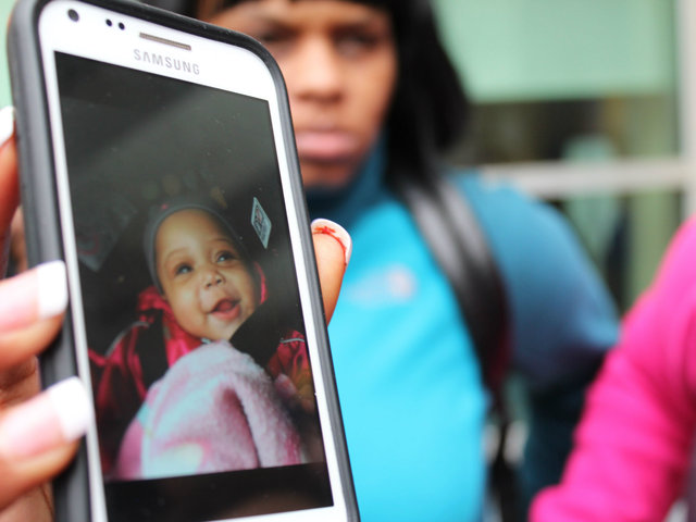 <p>Family holds up a photo of 6-month-old Jonylah Watkins.</p>
