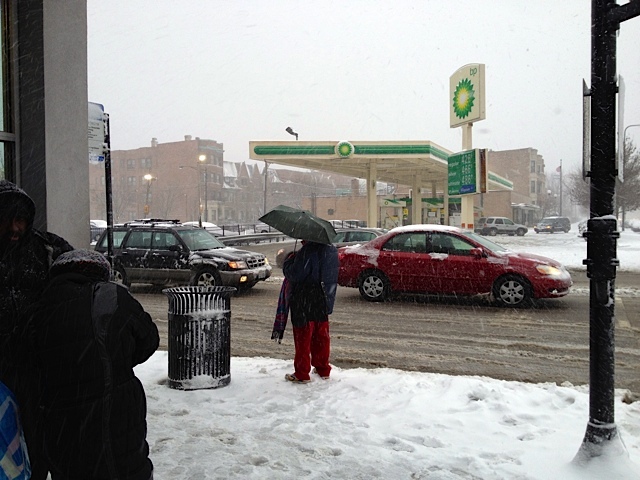 <p>People wait for a bus at 35th Street and King Drive during a snowstorm Tuesday.</p>
