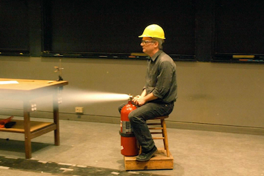 Professor Heinrich Jaeger uses a fire extinguisher to propel himself across the room during a previous "Physics with a Bang!" lecture.