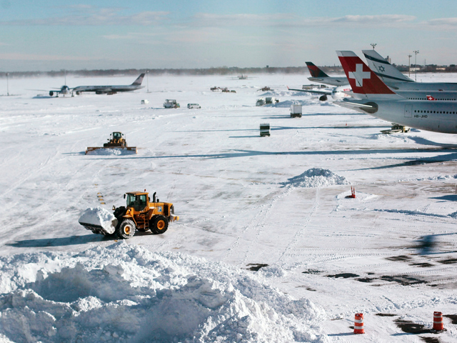 <p>Heavy equipment clears snow from the tarmac around Terminal 4 following a major blizzard at John F. Kennedy International Airport December 27, 2010 in the Queens borough of New York City. A massive snowstorm crippled much of the Northeastern United States leaving up to a foot of snow for New York City and New England and left millions of holiday travelers stuck at airports and train stations around the eastern seaboard.</p>
