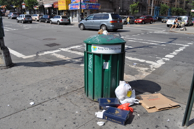 Garbage pours out of a garbage can over the weekend in Inwood.