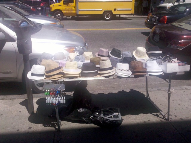 A vendor sells hats on St. Nicholas Avenue.
