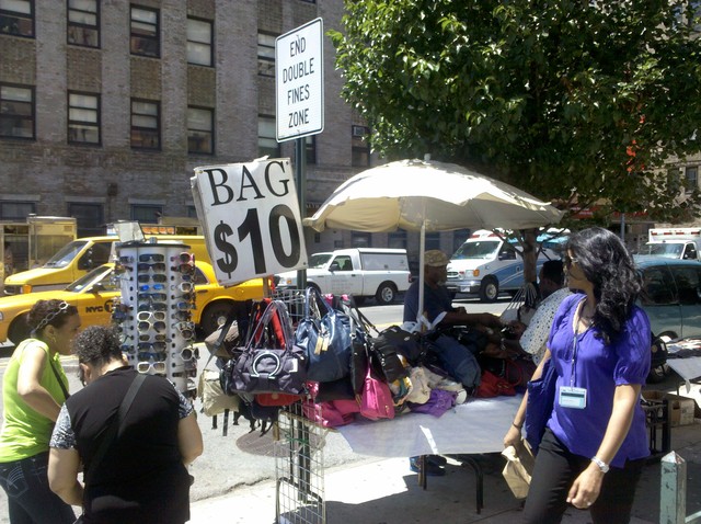 A vendor sells $10 handbags on Broadway and 168th Street.