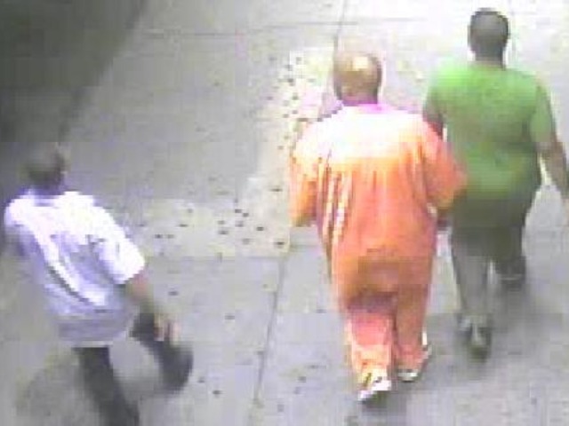A rear view of the suspect (center) and two men who were walking with him.