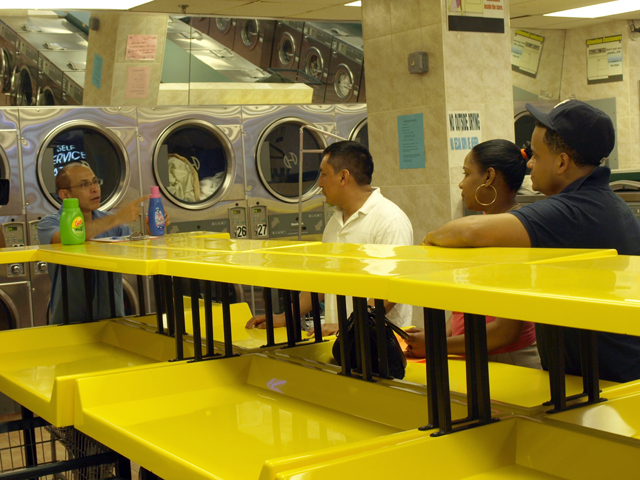 Hector Canonge talks to Inwood residents about his English classes being held at the laundromat. 