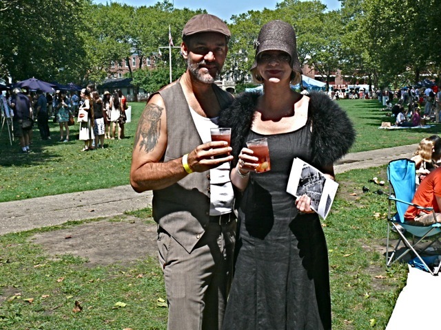 A present day New York style 20s a black linen summer dress with a feather stole and straw cloche.