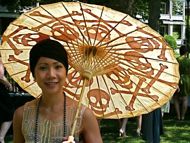  A richly embellished flapper inspired dress with a very bohemian turban and a wonderfully whimsical scull and cross bones parasol