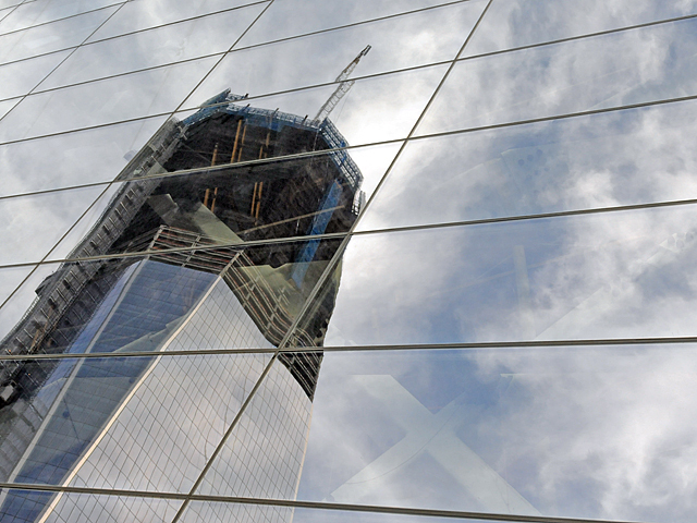 One World Trade Center is seen in a reflection on the 9/11 Museum Pavilion. 