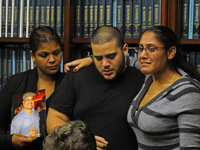 John Collado Jr. (center) is consoled by his cousins  Yajaira Brion (left) and Banayz Taveras. His father was shot and killed by a cop during an undercover drug bust in Inwood on Sept. 6, 2011.