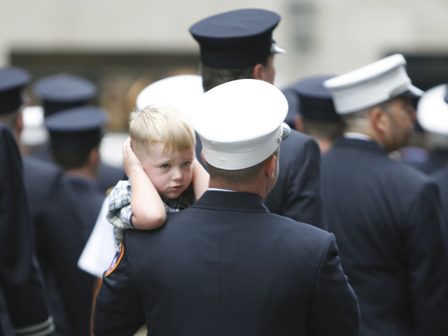 A young reveler at the Labor Day Parade on Sept. 10, 2011, being held by a member of the FDNY, finds all the noise a little too loud for his liking.