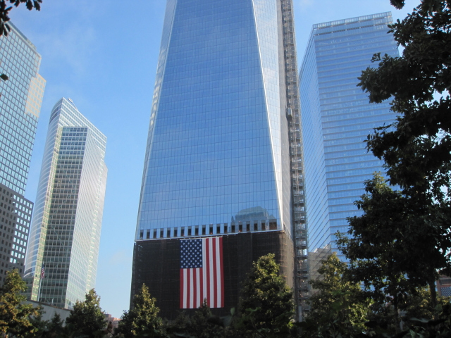 One of the rising World Trade Center buildings is visible from the 9/11 Memorial. 