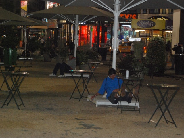 A man sleeps in the plaza space directly in front of Macy's Herald Square, Tues., Sept. 13.