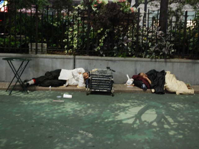 A man and woman sleep in the plaza space directly in front of Macy's Herald Square, Wed., Sept. 14.