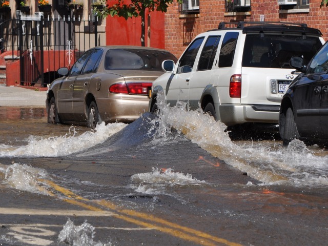Water washes against parked cars Monday.
