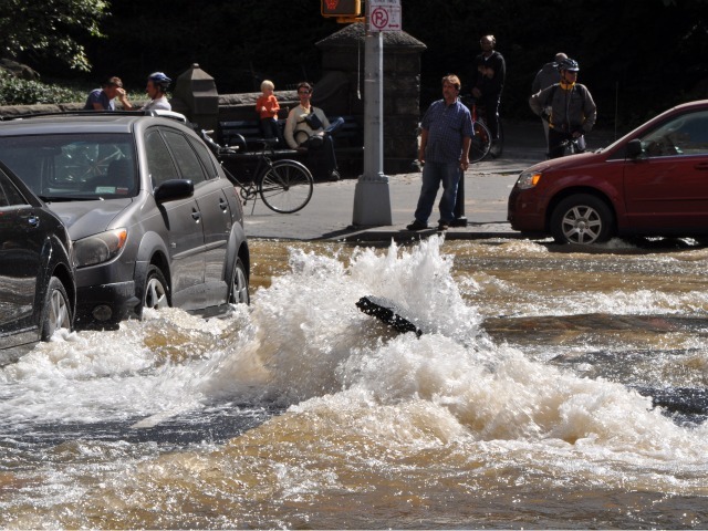 Water floods onto Central Park West Monday.
