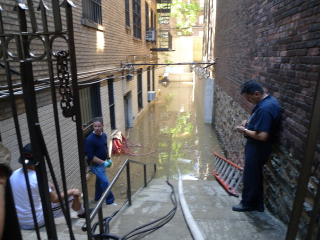 Crews pumped water out of a flooded courtyard  at 467 Central Park West after a water main break.