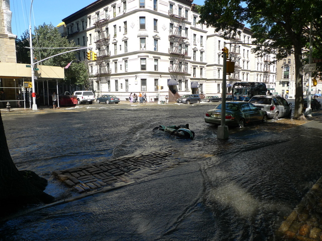 A water rushing down Central Park West after a water main break toppled a motorcycle parked on the street.