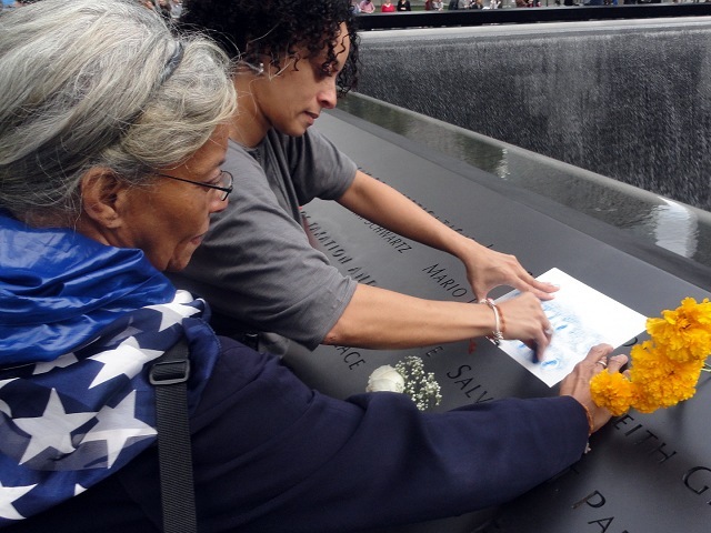 Yesenia L. Rodriguez, 38, of the Lower East Side made a rubbing from the name of childhood friend Mario L. Santoro, an EMT, at the 9/11 Memorial during community day on Oct. 2, 2011. Her mother, Raquel Rodriguez looks on. 