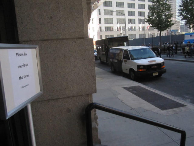 The management of 120 Greenwich St. put up a sign asking people not to sit on the steps, after 9/11 Memorial tourists frequently hung out there. 