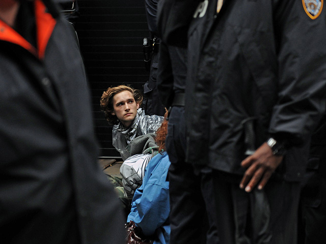 One of the younger protesters sits on the ground after being arrested. 