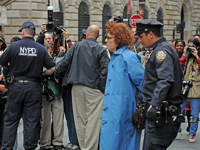 The woman is escorted to the police van. 