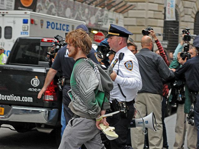 One of the protesters arrested carried a Guy Fawkes mask after being handcuffed. 