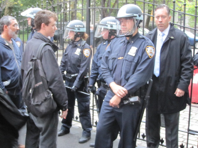 A protester stares down police at the entrance to City Hall on Broadway during an Occupy Wall Street march on Fri., Oct. 14, 2011.