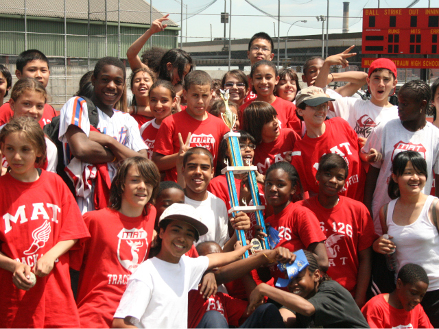 The track team at the Manhattan Academy of Technology celebrated a trophy. The school is one of many across the city that is now facing cuts to its coaching funding. 