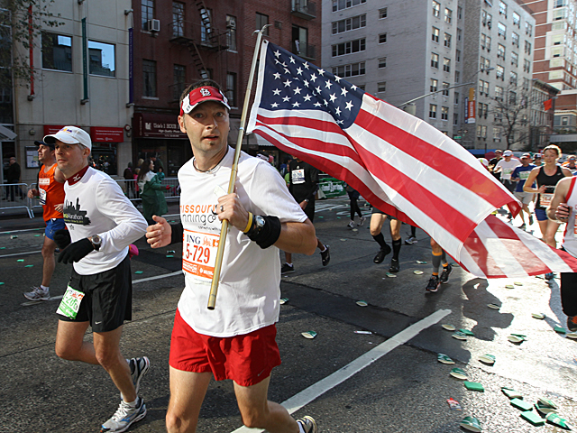 <p>A runner flies the American flag during this years NYC Marathon.</p>
