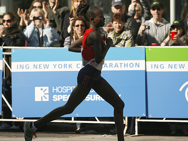 <p>A runner passes the cheering crowd during the NYC Marathon.</p>
