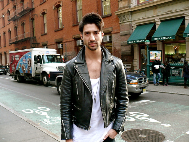 Daniel B. in a classic style biker jacket, with a wide necked t-shirt and volume brushed hair.