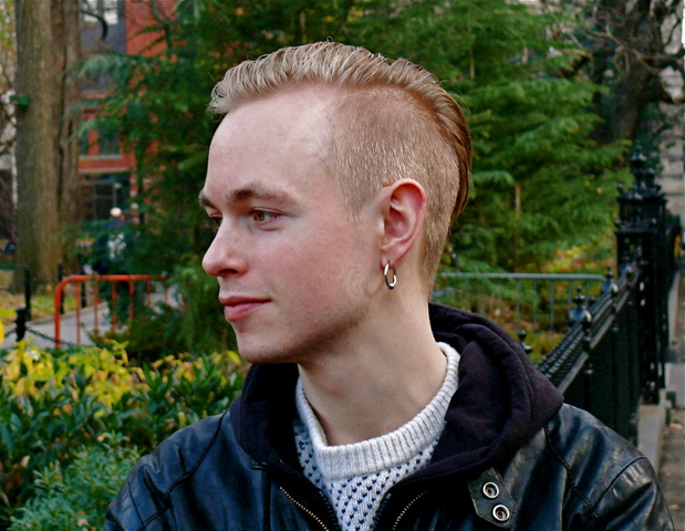 Trond B. in a black cotton hoodie and biker jacket and hand knitted sweater.